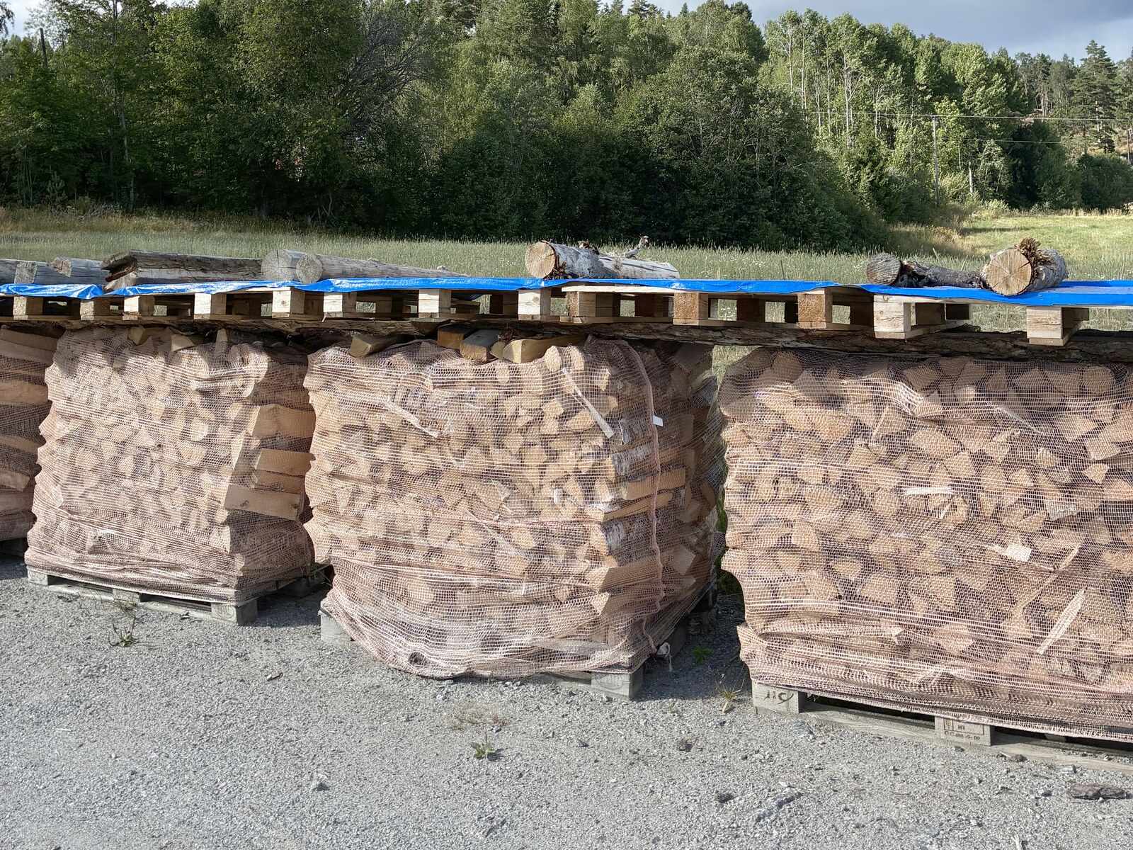 Tørr, kløyvd ved i 1000-liters storsekker på pall
